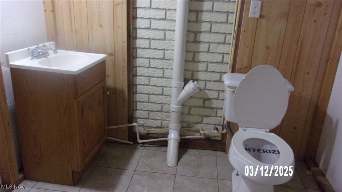 2270 Tatmans Road Southeast Corning, OH 43730 - Photo 13 of 14 Bathroom with tile patterned floors, wood walls, toilet, and vanity