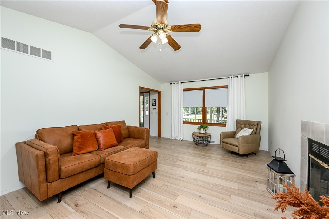 4845 State Road Medina, OH 44256 - Photo 16 of 47 Living area with a fireplace, lofted ceiling, light wood finished floors, and a ceiling fan