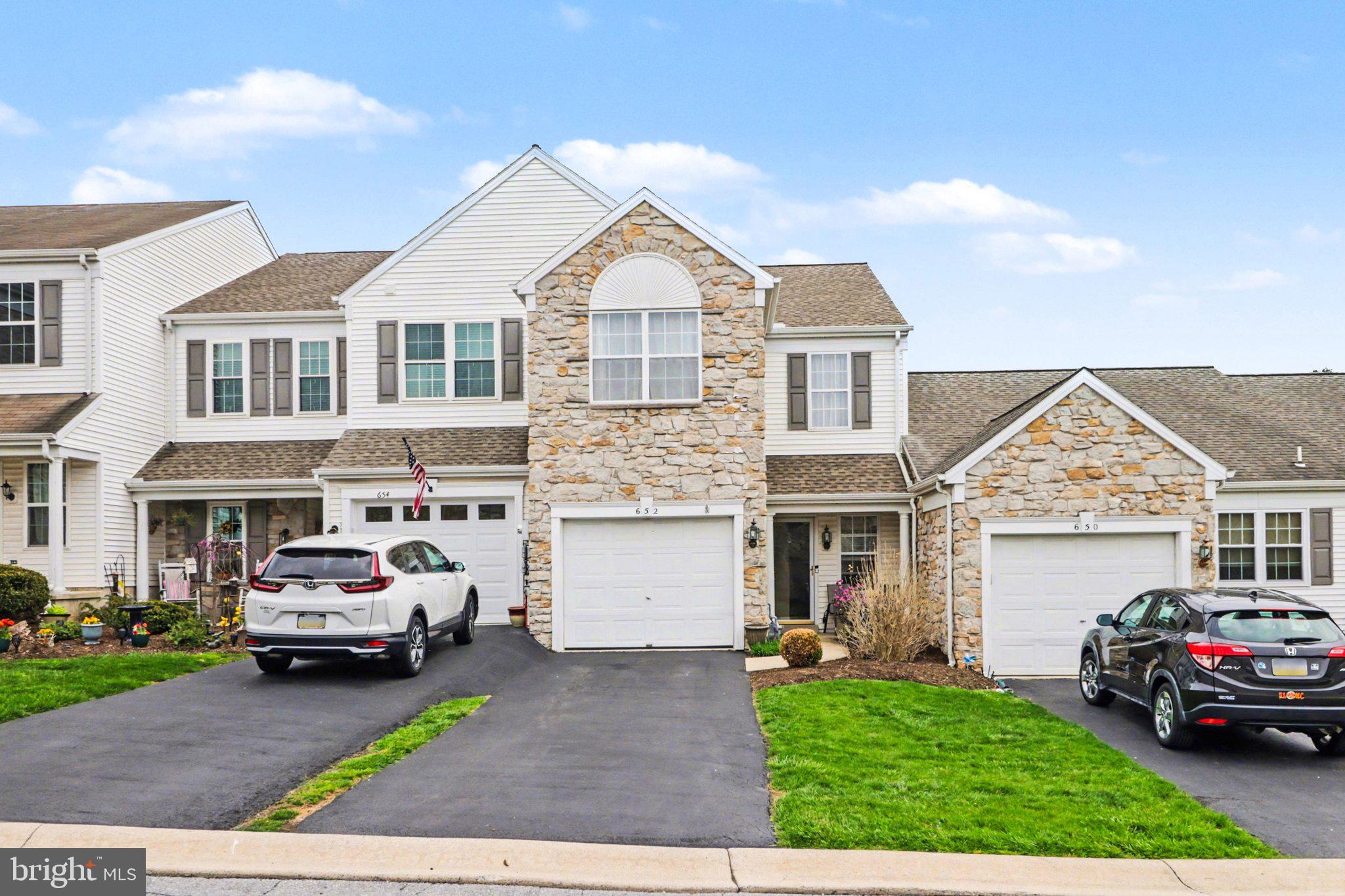 a front view of a house with a garden and parking space