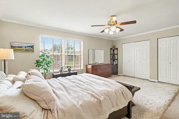 a bedroom with a large bed and a chandelier fan