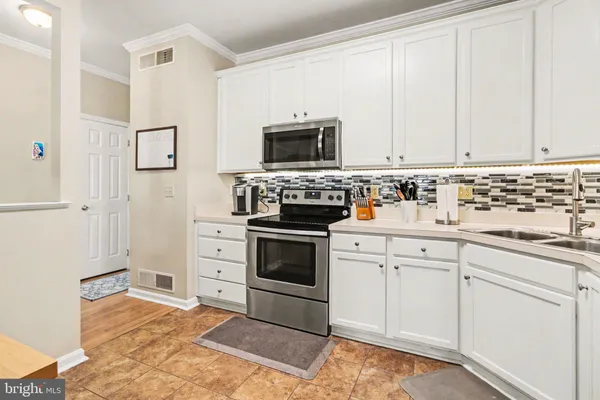 a kitchen with white cabinets and stainless steel appliances