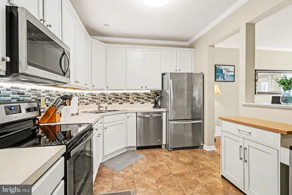 a kitchen with stainless steel appliances a refrigerator stove microwave and sink