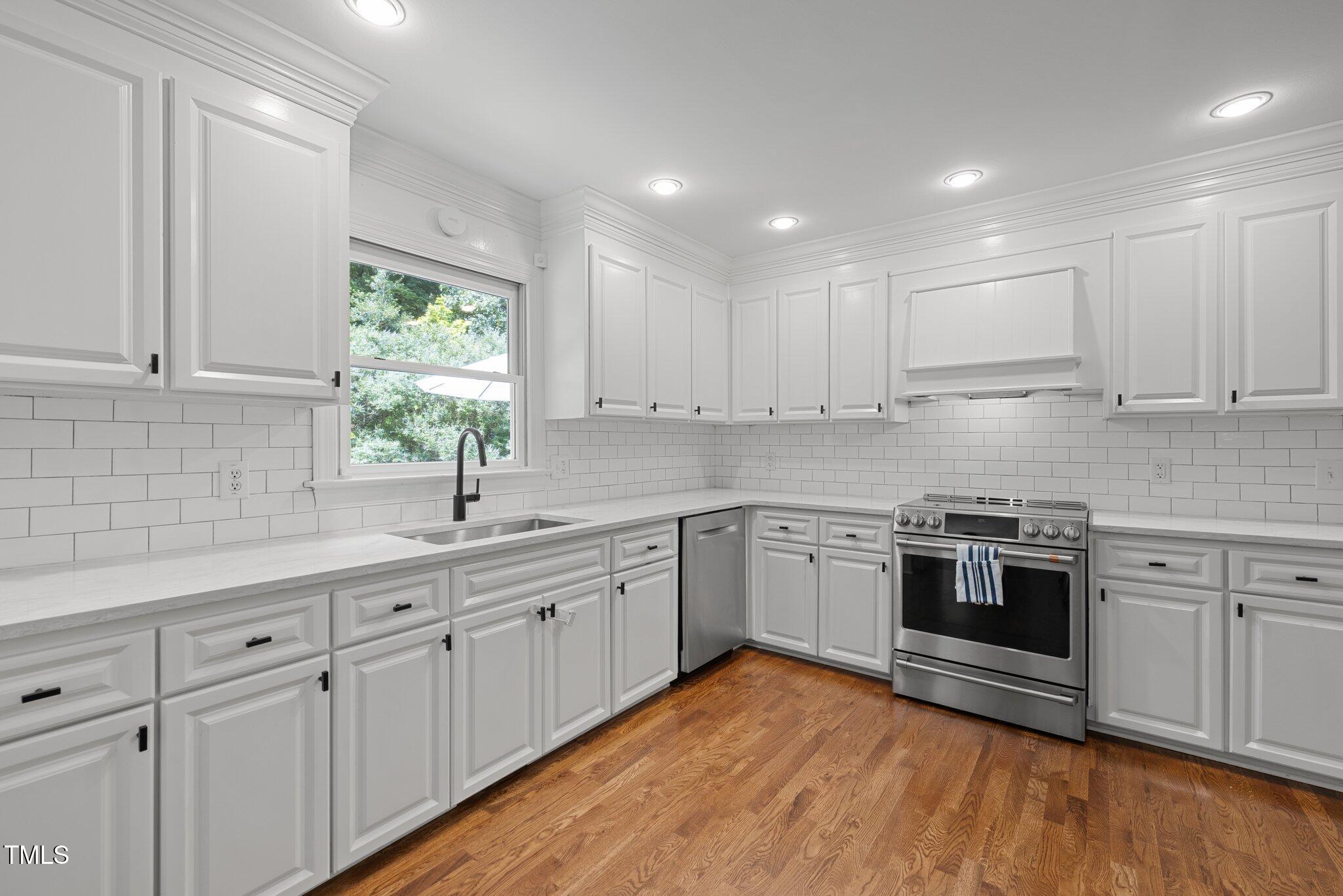 1706 Rangecrest Road Raleigh, NC 27612 - Photo 14 of 43 a kitchen with white cabinets sink and appliances