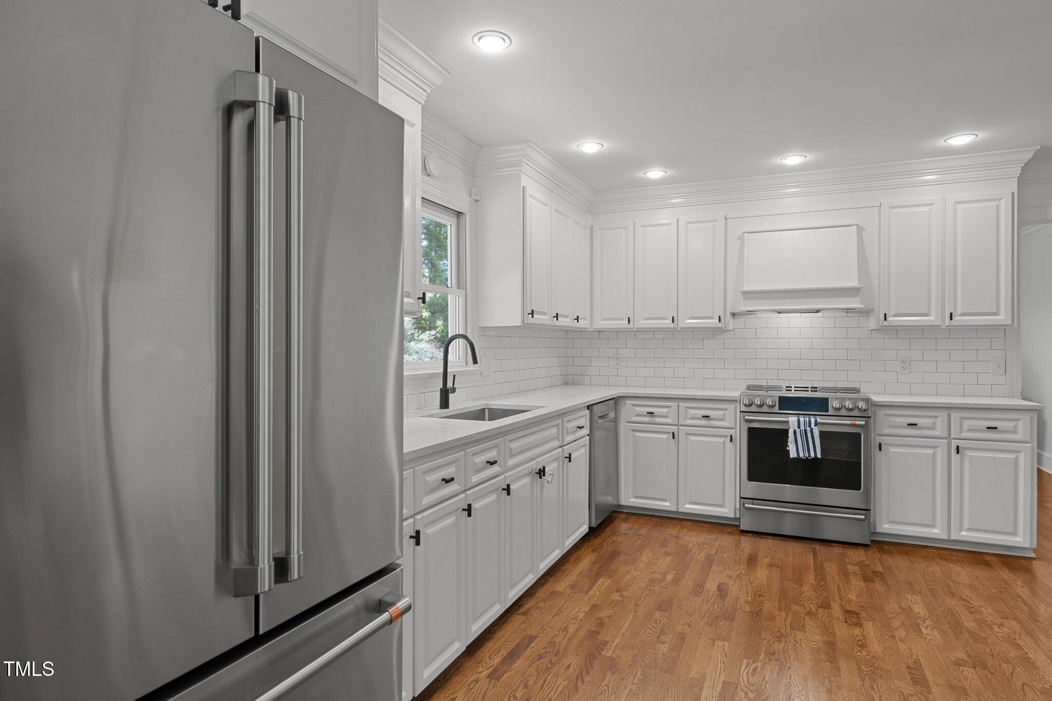 1706 Rangecrest Road Raleigh, NC 27612 - Photo 15 of 43 a kitchen with stainless steel appliances granite countertop a stove a sink and a refrigerator