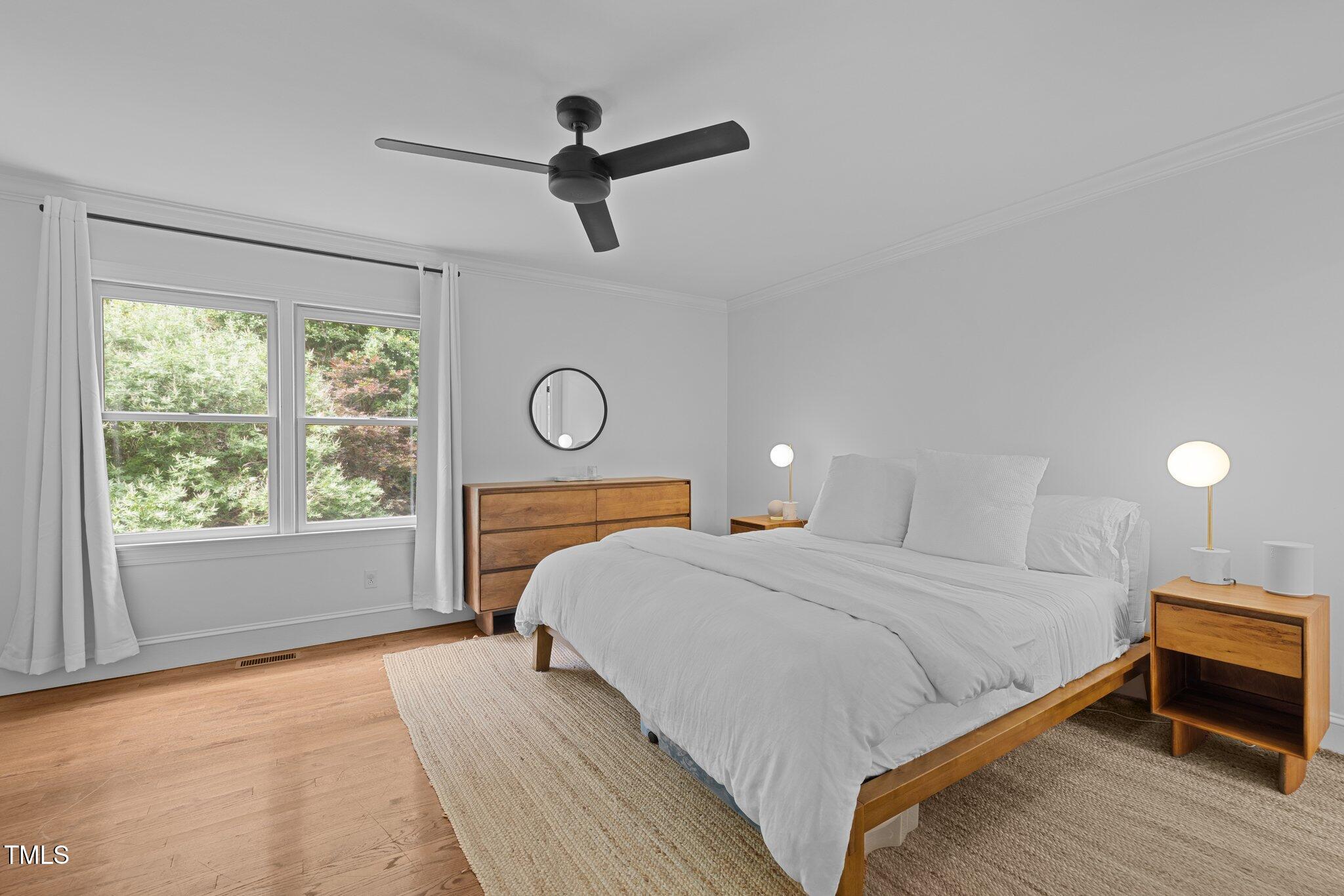 1706 Rangecrest Road Raleigh, NC 27612 - Photo 17 of 43 a bedroom with a bed a window and a chandelier