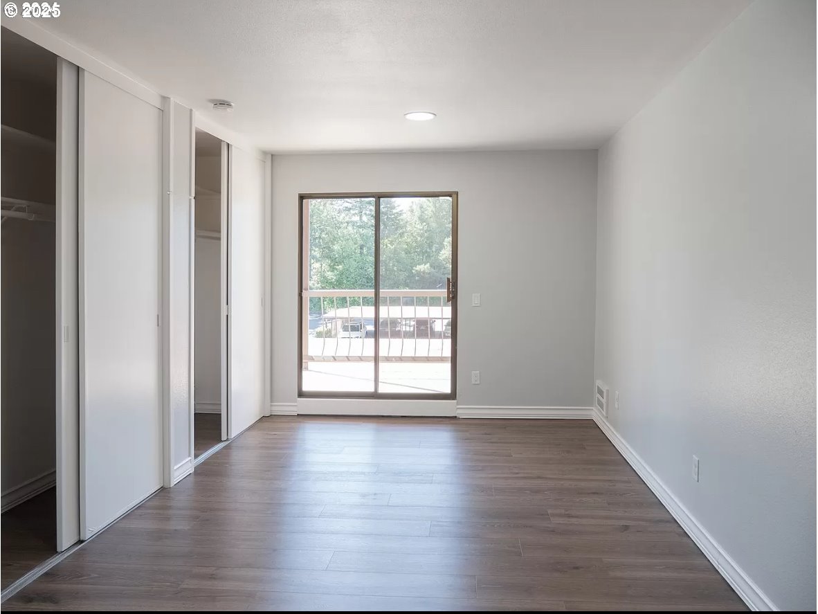 45 Eagle Crest Drive, Unit 407 Lake Oswego, OR 97035 - Photo 10 of 28 a view of an empty room with wooden floor and a window