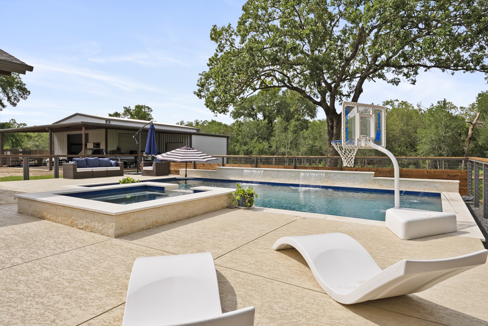 2802 Robin Road Manchaca, TX 78652 - Photo 1 of 40 Expansive outdoor living area featuring a swimming pool with water features, an integrated spa, and a textured concrete patio