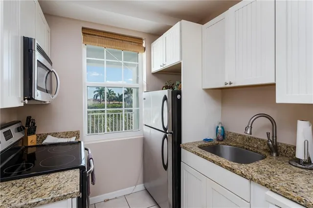 a kitchen with stainless steel appliances granite countertop a refrigerator sink and stove
