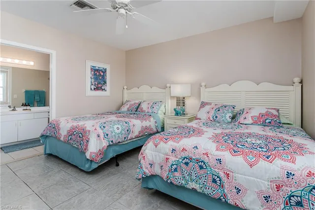 a bedroom with two beds and a chandelier