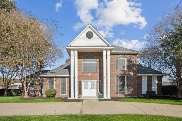 a front view of a house with a yard and trees