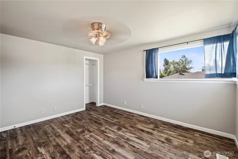 a view of a room with wooden floor and windows