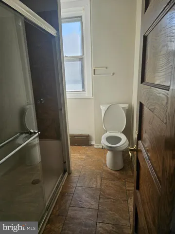 a bathroom with a toilet and a shower