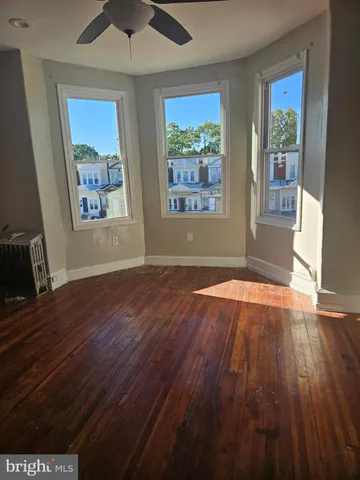 a view of empty room with window and wooden floor