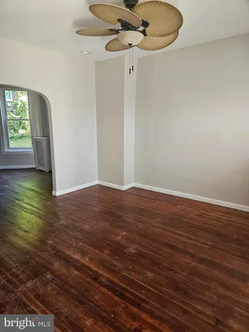 a view of a livingroom with wooden floor and a ceiling fan