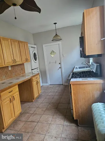 a kitchen with granite countertop a sink a stove a refrigerator and cabinets