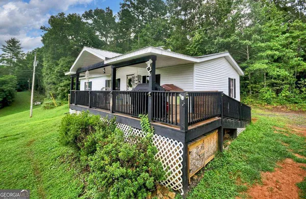 a view of a house with a yard and deck fence