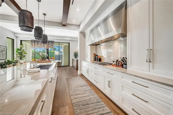 a large white kitchen with granite countertop lots of counter top space