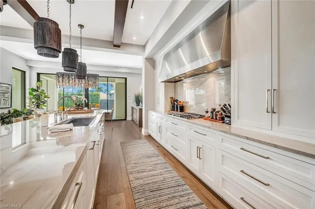 a large white kitchen with granite countertop lots of counter top space