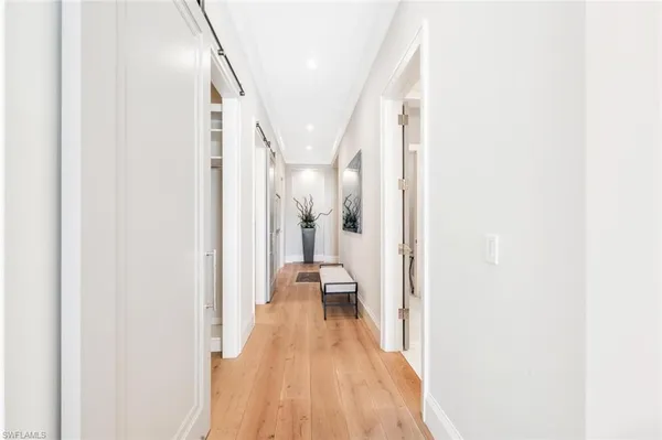 a view of a hallway with wooden floor and staircase
