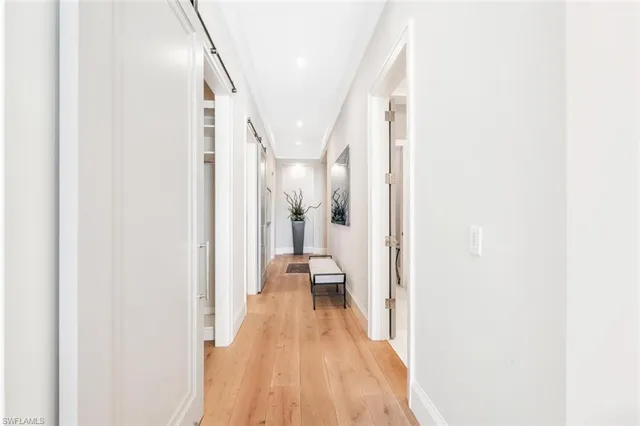 a view of a hallway with wooden floor and staircase