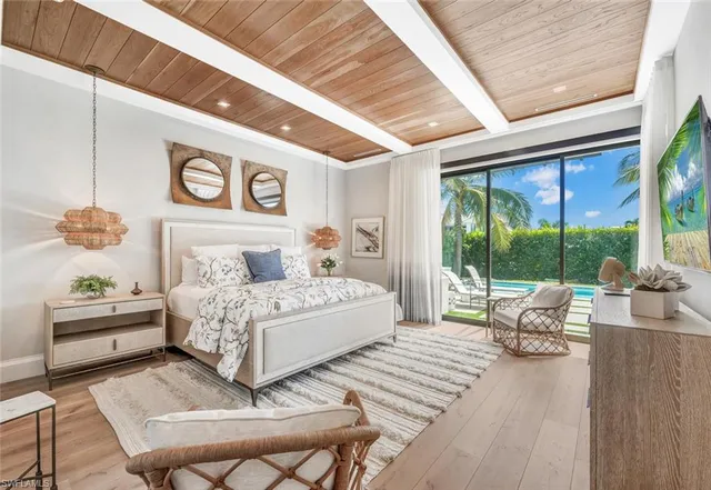 a bedroom with a bed and large windows