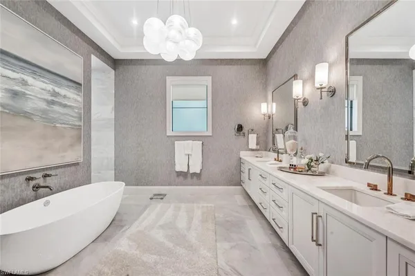 a spacious bathroom with a double vanity sink mirror and chandelier