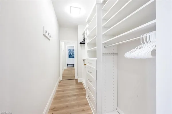 a view of a hallway with wooden floor and entryway