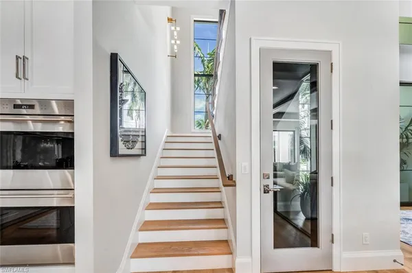 a view of a hallway with wooden floor and staircase