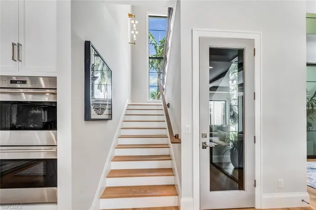 a view of a hallway with wooden floor and staircase