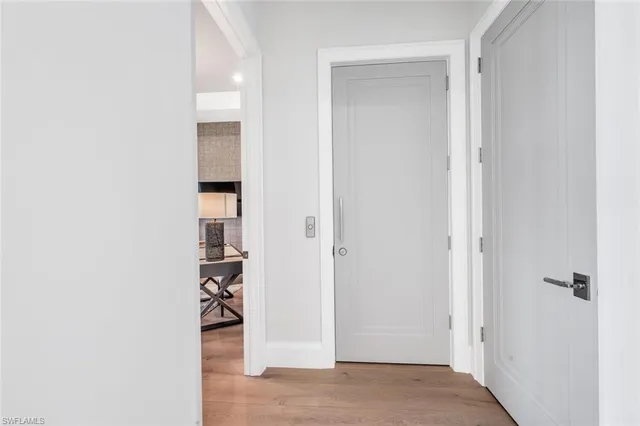 a view of a hallway with wooden floor and closet