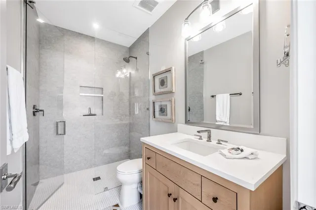 a bathroom with a sink toilet a mirror and shower