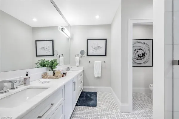 a spacious bathroom with a double vanity sink and a mirror