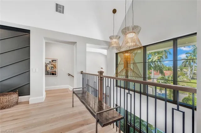 a view of a hallway with wooden floor and chandelier