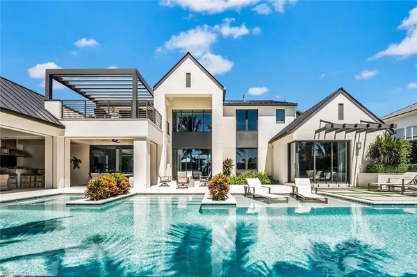 a view of a house with swimming pool and sitting area