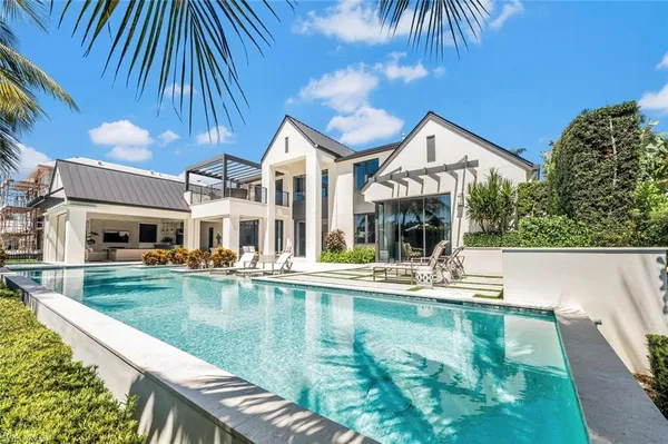 a view of a house with pool and chairs