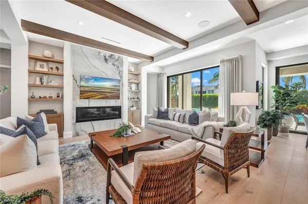 a living room with furniture a flat screen tv and a large window