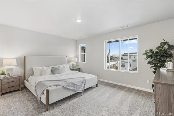 a bedroom with a bed potted plant on dresser and a window