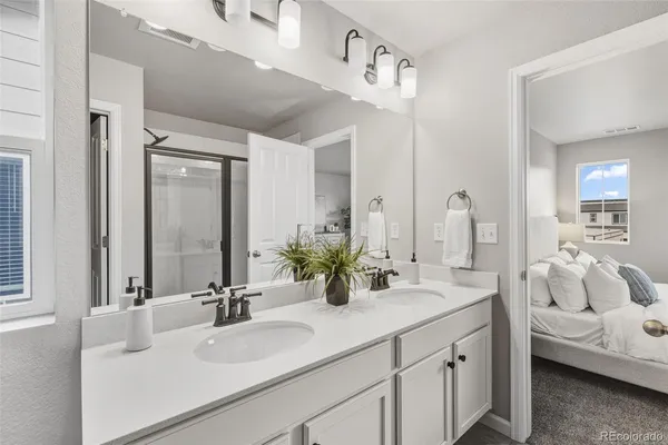a bathroom with double vanity sinks and a mirror