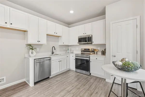 a kitchen with stainless steel appliances a stove a sink a refrigerator and a microwave