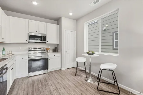 a kitchen with granite countertop a stove a sink and a refrigerator
