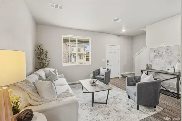 a living room with furniture ceiling fan and a window