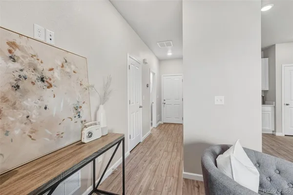 a view of a room with wooden floor and furniture