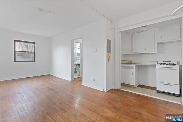 a view of a kitchen with wooden floor and electronic appliances