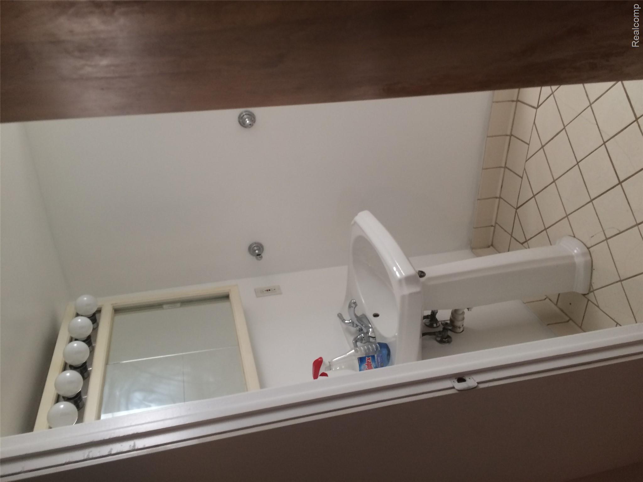 30057 Spring Arbor Drive Inkster, MI 48141 - Photo 6 of 9 Pedestal sink with chrome faucet, a mirrored medicine cabinet, and a five-bulb vanity light fixture