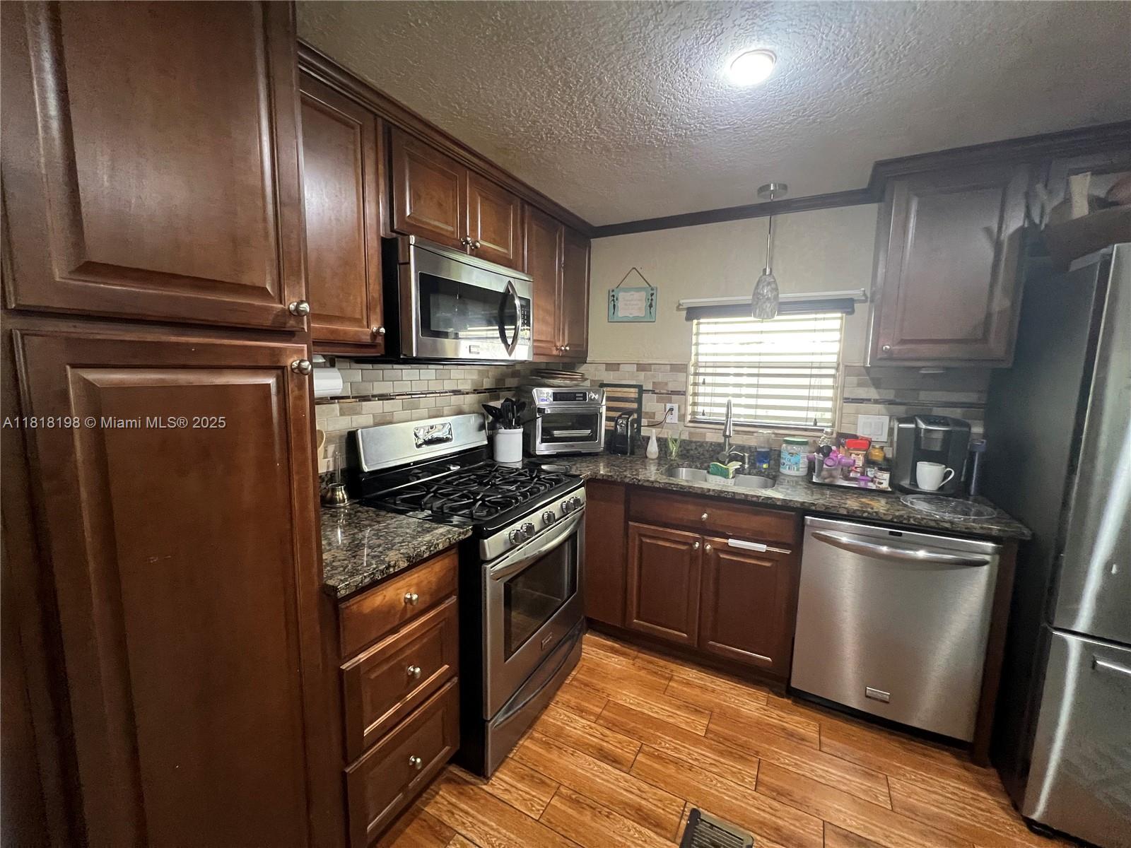 Davie Davie, FL 33324 - Photo 11 of 25 a kitchen with stainless steel appliances granite countertop a stove refrigerator sink and microwave