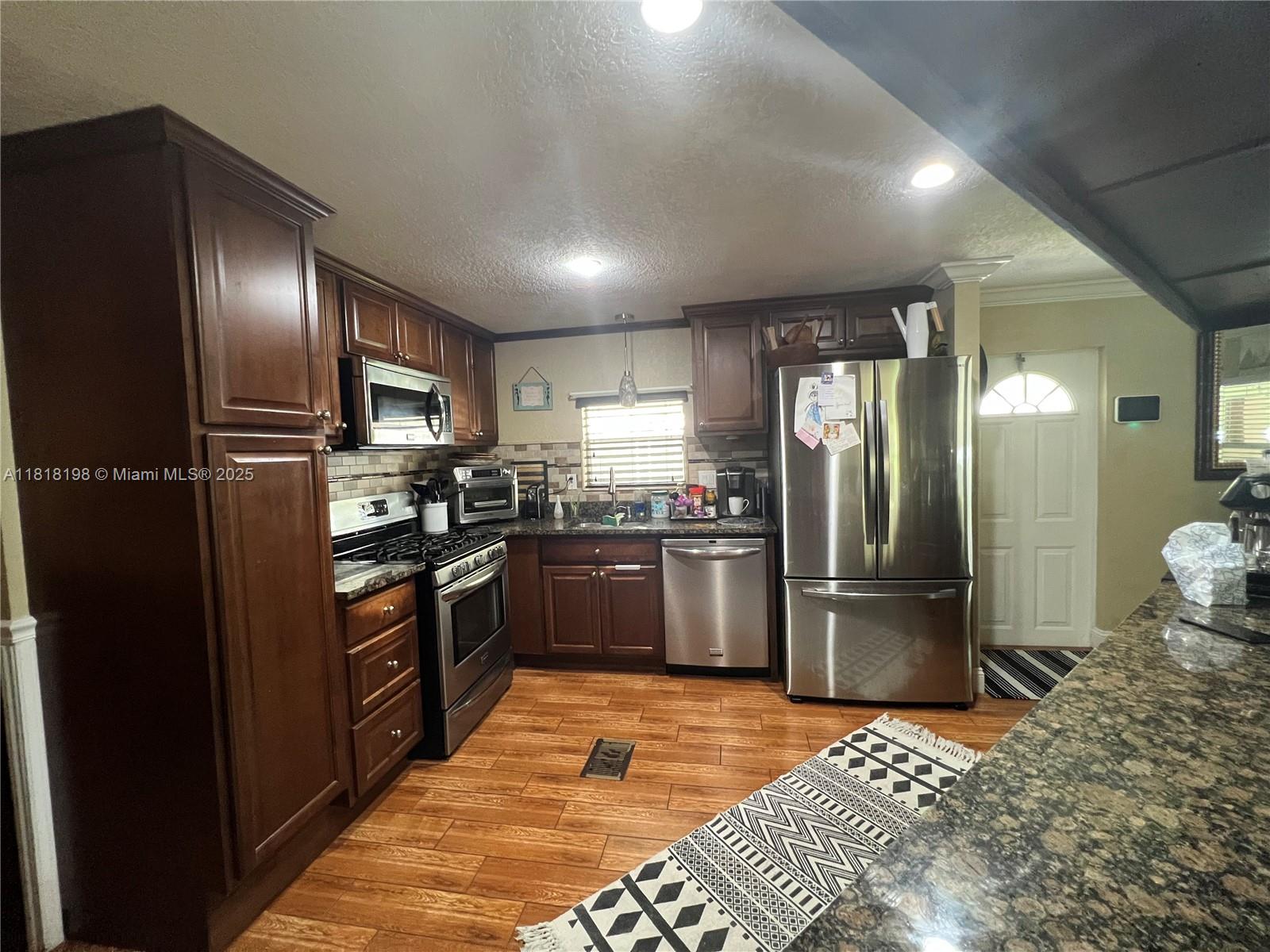 Davie Davie, FL 33324 - Photo 12 of 25 a kitchen with granite countertop stainless steel appliances and refrigerator