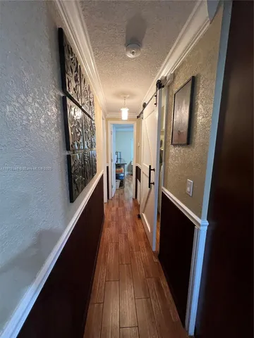 a view of a hallway with wooden floor and staircase