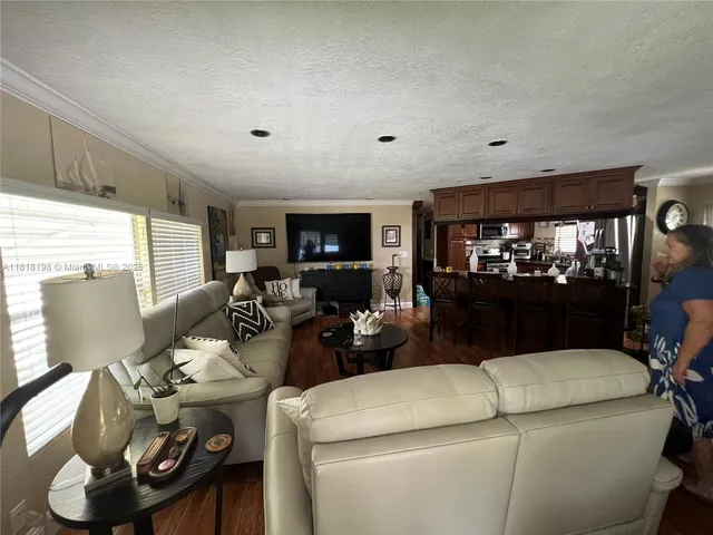 a living room with furniture a flat screen tv and a floor to ceiling window