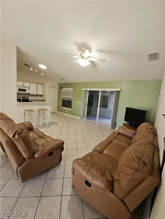 a living room with furniture and kitchen view
