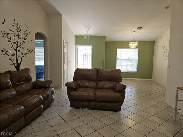 a living room with furniture and a chandelier